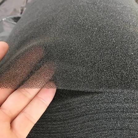Hand holding fine-pore black polyether reticulated foam